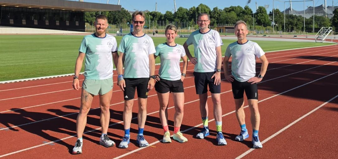 Gruppenbild MRA Fünf Sportler in Laufkleidung stehen auf einer Laufbahn mit Rasen im Hintergrund.